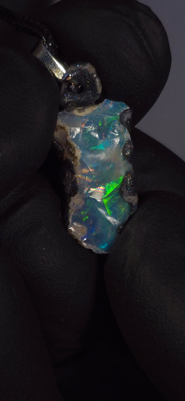 Collier en opale — Feu et éclats multicolores, fond bleu clair