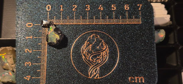 Raw uncut Ethiopian Welo opal pendant with multicolour pinfire. Placed next to a steel ruler for scale.