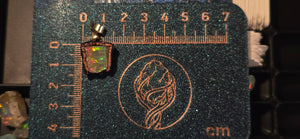 Raw uncut Ethiopian Welo opal pendant. Colour: green, gold, red, full rainbow, vivid. Body: dark. Placed next to a steel ruler for scale.
