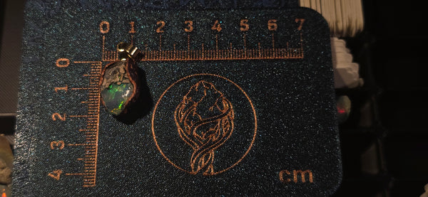 Raw uncut Ethiopian Welo opal pendant. Colour: full rainbow, vivid. Body: blue. Placed next to a steel ruler for scale.