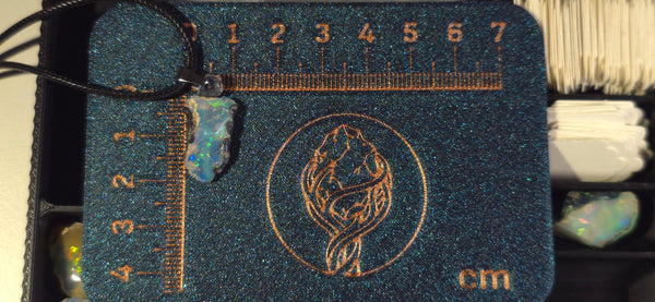 Collier en opale — Feu et éclats multicolores, fond bleu clair